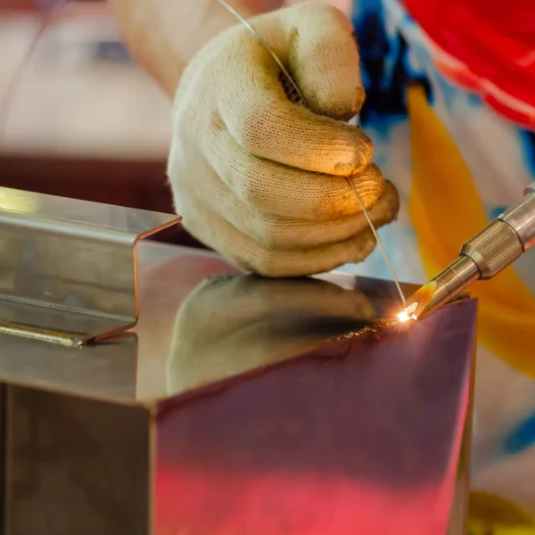 Welder hands using portable handheld laser welding machine - close up. Manufacturing, industrial, equipment, technology and metalworking concept